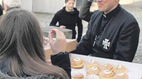 Pater Norbert Rasim verteilte danach Krapfen an die Gläubigen.