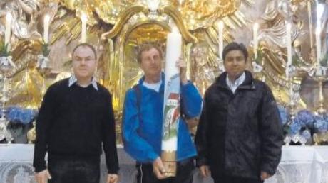 Pfarrer Manfred Bauer (links) und Pater Justin segneten in Andechs die neue Kerze der Pfarrei, die Josef Drexl (Mitte) durch das Kiental getragen hatte. 