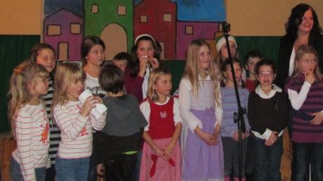 Nach der Aufführung der Gedichte und Weihnachtslieder stellten sich die Kinder und Maria Grabmann (rechts) und Johanna Tremmel (hinten), die zum Einstudieren verantwortlich waren, zum Gruppenfoto und ernteten viel Applaus. 