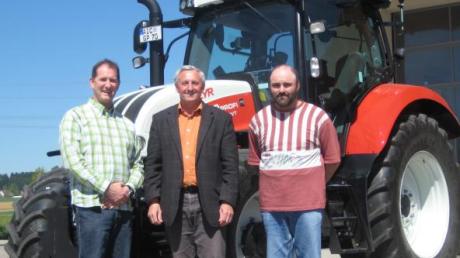 Die Bauhofmitarbeiter Richard Brandmair (links) und Bernhard Engelhard (rechts) sowie Bürgermeister Johann Settele (Mitte) nahmen den Traktor in Empfang. 

