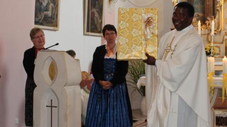 Pastoralratsvorsitzende Centa Plöckl und stellvertretende Pastoralratsvorsitzende Sofia Brandmayr überreichen (von links) Pater Vitalis ein Messgewand.
