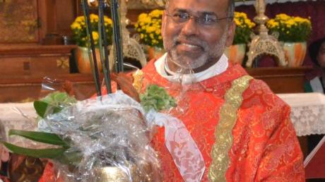 Pater Babu mit dem Begrüßungsgeschenk der Pfarreiengemeinschaft.