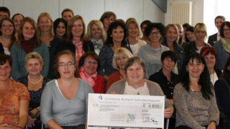 Mit 4800 Euro unterstützt die Sparkasse Aichach-Friedberg die Knaxiade an den Kindergärten im Landkreis Aichach-Friedberg und in Schrobenhausen. Birgit Cischek (rechts hinten) überreichte den Scheck den Erzieherinnen der Kindergärten. 
