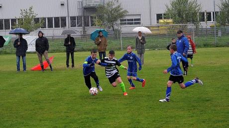 Zweikampf bei strömenden Regen: Aichachs E1-Kapitän Lorenz Greifenegger (links) versucht den Ball vor einem Friedberger Gegenspieler zu schützen. 