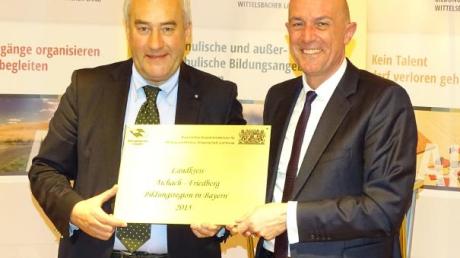 Kultusminister Ludwig Spaenle überreicht das Siegel an den Landrat Klaus Metzger. 