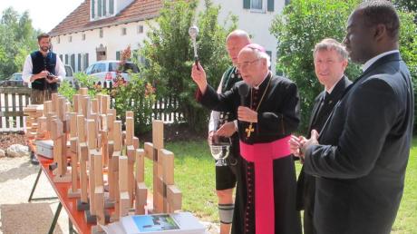 Weihbischof Josef Grünwald (zweiter von links) segnet die Kreuze, die aus Holz vom alten Dachstuhl gefertigt wurden. Von rechts Pater Emanuel, Stadtpfarrer Herbert Gugler und Kirchenpfleger Georg Ostermaier.