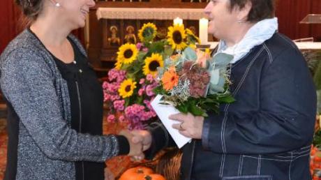 Rita Königsdorfer überreicht Elisabeth Friedel (links) Blumen und ein Präsent.