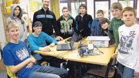 Mit Hilfe von Dominik Merli (Vierter von links) lernen die Schüler, Legoroboter zu bauen und zu programmieren. 