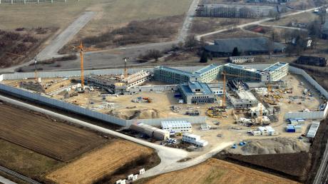 Hinter der Gefängnismauer sind die Arbeiter von 14 Firmen am Werk. Sie treiben das 100-Millionen-Euro-Projekt planmäßig voran. Mitte 2015 sollen dort die ersten Häftlinge einziehen. 