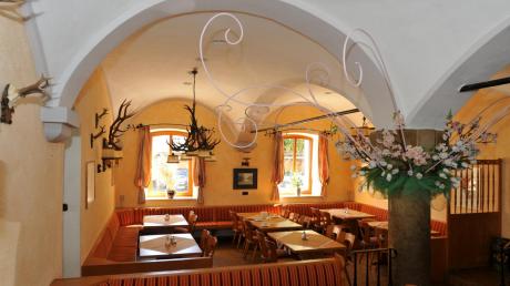 Die helle und freundliche Gaststube des Traditionswirtshauses Neue Post in Meitingen mit ihrem Gewölbe und Trophäen an den Wänden 
