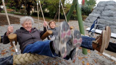Sie haben gemeinsam Spaß: Die 83-jährige Waltraut Reiter und der zwölfjährige Jonas Günther schaukeln gemeinsam in dem neuen Generationengarten, der Jung und Alt miteinander in Kontakt bringen soll.  

