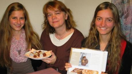 Stolz zeigt Anita Lindenmayr (Mitte) den Teller mit Weihnachtstrüffeln, die sie mit ihren Töchtern Michaela (links) und Bettina gebacken hat.  
