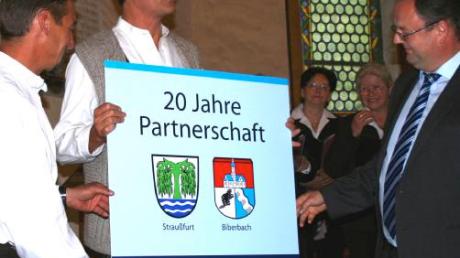 Klaus Gerstmayr und Wolfgang Jarasch (von links) überreichen eine Erinnerungsplakette an den Straußfurter Bürgermeister Olaf Starroske.  
