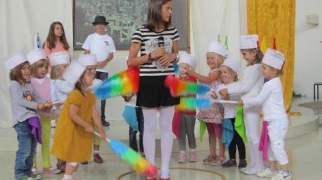 Musical-Darstellerin Lea Fährmann, umringt von Kindern der Kita Herz Mariä, verkleidet als kleine „Muchacha“.