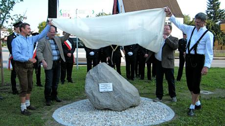 Bürgermeister Wolfgang Jarasch (von rechts) und sein Amtskollege Olaf Starroske enthüllen den Gedenkstein mit der Hilfe ihrer Stellvertreter Jens Adreß und Klaus Gerstmayr. 