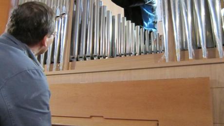 Orgelbauer Gennady Burdeyko entlockt der Orgel am Spieltisch die ersten Töne, damit Martin Geßner die Pfeifen passend für den Kirchenraum intonieren kann. 