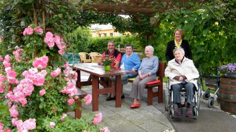 Die Pergola ist nur eine von vielen idyllischen Ecken im Garten der Seniorenanlage in Langweid. Hausmeister Horst Hüll (links) sorgt dafür, dass es so bleibt. 	 	