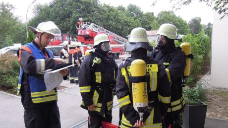 Gruppenführer Patrick Theis weist die Trupps der Langweider Feuerwehr mit schwerem Atemschutz ein. 