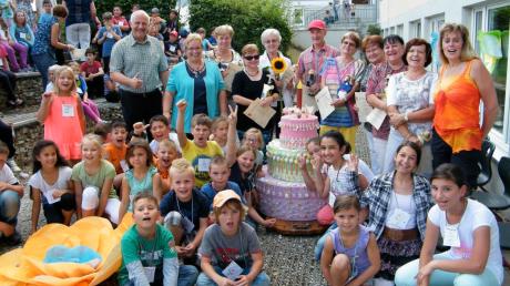 Mit einer riesigen, bunten Geburtstagstorte aus Pappe und Bonbons feierten in Langweid Grundschüler und Betreuer gleich drei Jubiläen auf einmal. 	