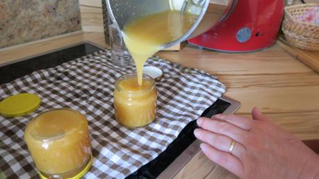 Uschi Faulhaber füllt die Pfirsich-Nekarinen-Marmelade in die Weckgläser. Die werden erst einmal umgedreht, so sind sie später lange haltbar. 	