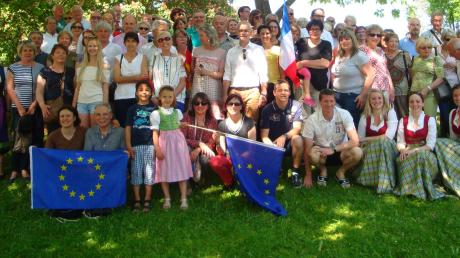 Ein schattiges Plätzchen bei großer Hitze: Die französischen Gäste und ihre Diedorfer Gastgeber in Anhausen mit der blauen Europa-Fahne. 	