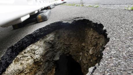 Ein defekter Anschluss riss ein Loch in die Straße. 	