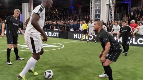 Usain Bolt (links) und Roberto Carlos spielen beim Hublot Match of Friendship auf der Uhrenmesse Baselworld eine Runde Fußball. Bald darauf trainiert er beim BVB.
