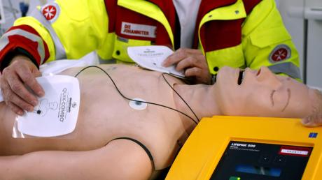 Ein Rettungssanitäter zeigt, wie ein Defibrillator funktioniert. (Symbolbild)