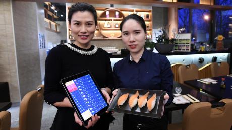 Xiao Dan Zhuge (links) und Jiang Shuhui haben in der alten Kuka-Kantine ein japanisches Restaurant eröffnet. Bestellt wird per iPad. 	