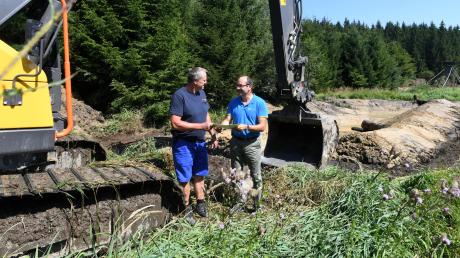 Im Anhauser Tal wird gegraben. Baggerfahrer Rudi Wiedenmann (links) und Hermann Stocker, der stellvertretende Leiter des Forstbetriebs Zusmarshausen, besprechen die nächsten Schritte. 	