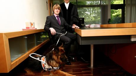 Richter Moritz Bißwanger mit seinem Blindenhund Daggy im Sitzungssaal. Rechts Richter Walter Hell.