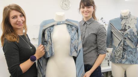 Martyna Meyr und Lisa Wagner (von links) sind Modedesign-Studenten. Sie haben die Muster der neuen Stoffe aus Augsburg entworfen und zusammen mit weiteren Studenten eine neue Kollektion angefertigt. Anfang März ist das Ergebnis in München auf dem Laufsteg zu sehen. 	 	