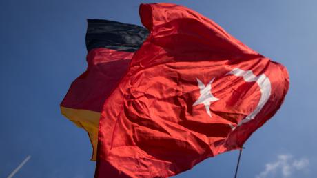 Eine türkische und eine deutsche Flagge flattern vereint im Wind. Die Realität im Verhältnis der beiden Staaten sieht derzeit ganz anders aus. 