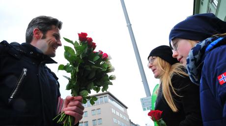 OB-Kand idat Dirk Wurm von der SPD verteilt rote Rosen an potenzielle Wählerinnen. 