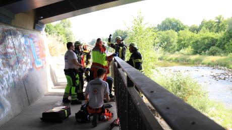 Berufsfeuerwehr und Rettungsdienst kümmerten sich in Augsburg um einen Mann, der mit seinem Knie in einem Brückengeländer feststeckte.