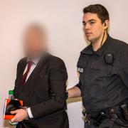 Auf der Weg in den Gerichtssaal: Der 42-jährige Angeklagte, Kopf der Gemeinschaft "Go&Change", wird am Montagmorgen am Landgericht Schweinfurt in Hand- und Fußfesseln vorgeführt.  