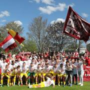 Party mit den Fans. Spieler und Trainer der Würzburger Kickers stellen sich vor den mitgereisten Anhängerinnen und Anhängern zum Gruppenbild auf.