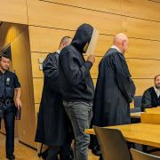 Mit Maske und Fußfessel wurde der Angeklagte (Mitte) in den Gerichtssaal des Würzburger Landgerichts geführt.