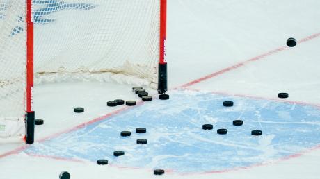 Eishockey-Pucks liegen im Torraum.
