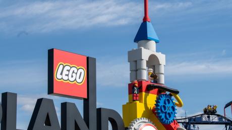 Neben dem Logo am Eingang zum Legoland ist eine Achterbahn zu sehen.