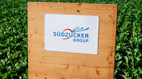 Ein Schild mit der Aufschrift „Südzucker Group“ steht an einem Feld mit Zuckerrüben.