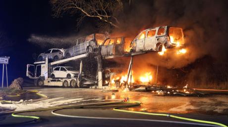 Mehrere Autos auf einem Autotransporter stehen in Flammen.