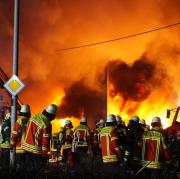 Einsatzkräfte der Feuerwehr löschen den Brand in mehreren Gebäuden bei der Firma Burgmaier in Allmendingen.