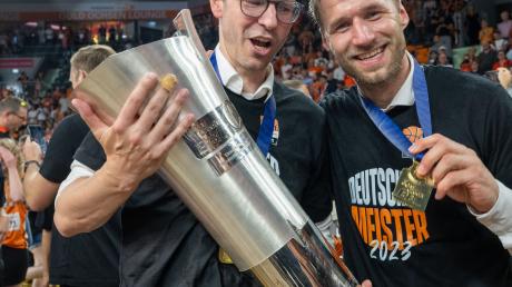 Ulms Trainer Anton Gavel (r) und Sportdirektor Thorsten Leibenath halten den Meisterpoikal.