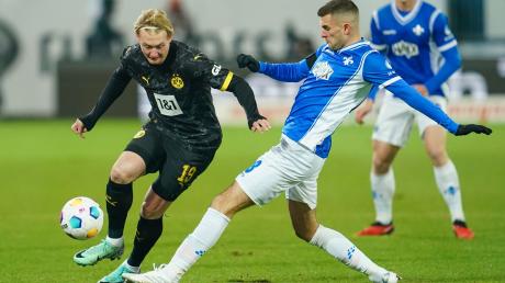Dortmunds Julian Brandt (l) und Darmstadts Bartol Franjic kämpfen um den Ball.