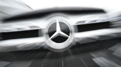 Das Logo der Automarke Mercedes-Benz ist an der Front eines Mercedes-Benz Fahrzeugs angebracht.