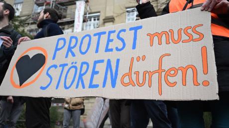 Vor dem Oberlandesgericht (OLG) Karlsruhe protestieren Klimaaktivisten mit einem Plakat auf dem steht «Protest muss stören dürfen!» gegen den Prozess, ob Straßenblockaden von Klimaaktivisten als Nötigung einzustufen sind.
