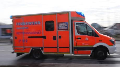 Ein Rettungswagen (RTW) der Feuerwehr fährt mit Blaulicht zu einem Einsatz.