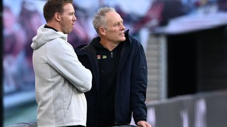 RB-Trainer Julian Nagelsmann (l) und Freiburgs Trainer Christian Streich unterhalten sich im Stadion. Christian Streich hält viel von Bundestrainer Julian Nagelsmann.