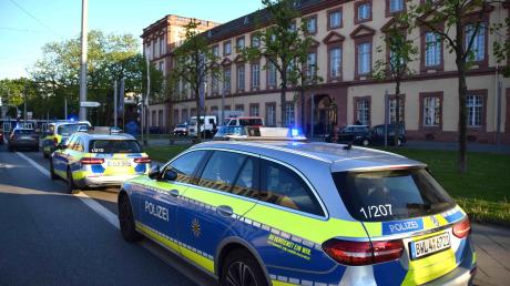 Fahrzeuge der Polizei stehen vor der Universität in Mannheim. Nach den tödlichen Schüssen auf einen mit einer Machete bewaffneten Mann in einer Mannheimer Universität laufen die Ermittlungen auf Hochtouren.